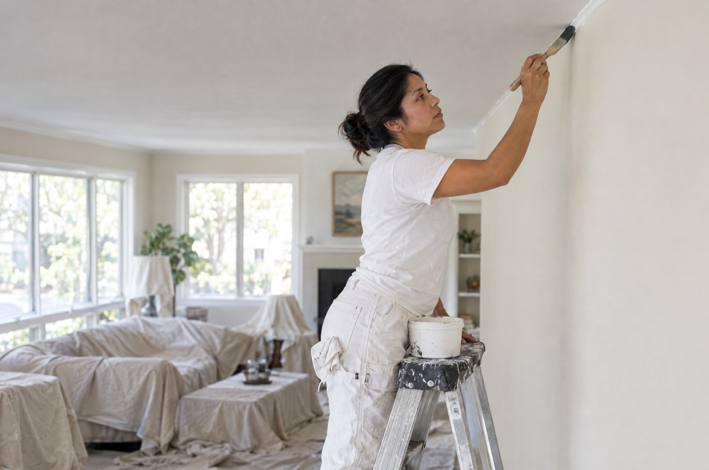 A painter cutting in where the wall meets the ceiling